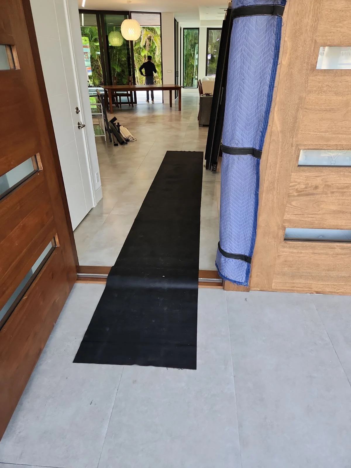 Lee's Moving crew installing floor and door frame protection at a luxury Boca Raton home